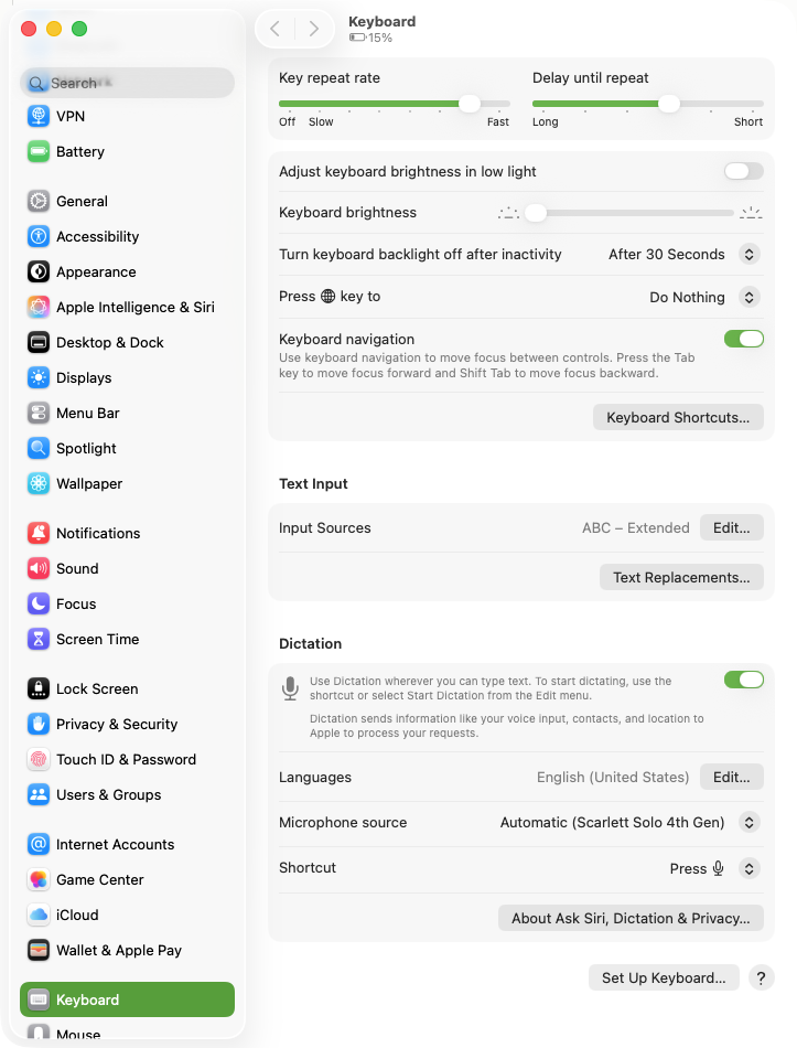 חלון System Settings של macOS כש-Keyboard מסומן בסרגל הצד, גלול עד מקטע Dictation שבו המתג ירוק ודלוק, שורת Languages מציגה English (United States), שורת Microphone source מציגה Automatic (Scarlett Solo 4th Gen), ושורת Shortcut מציגה Press ולידה סמל של מקש מיקרופון, בלי שום שורה של פיסוק אוטומטי במקטע